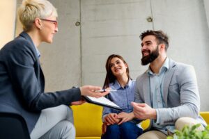 A woman is talking to two men in front of her.