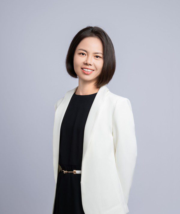 A woman in black dress and white jacket