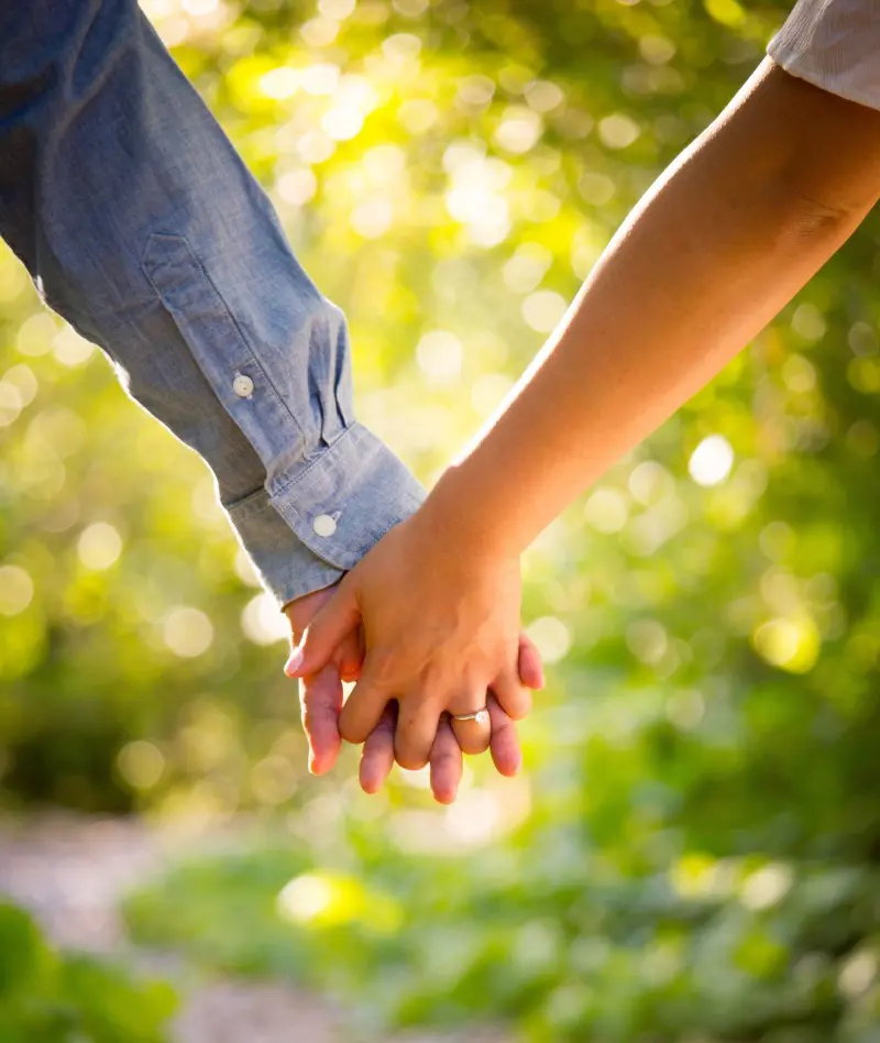 A close up of two people holding hands